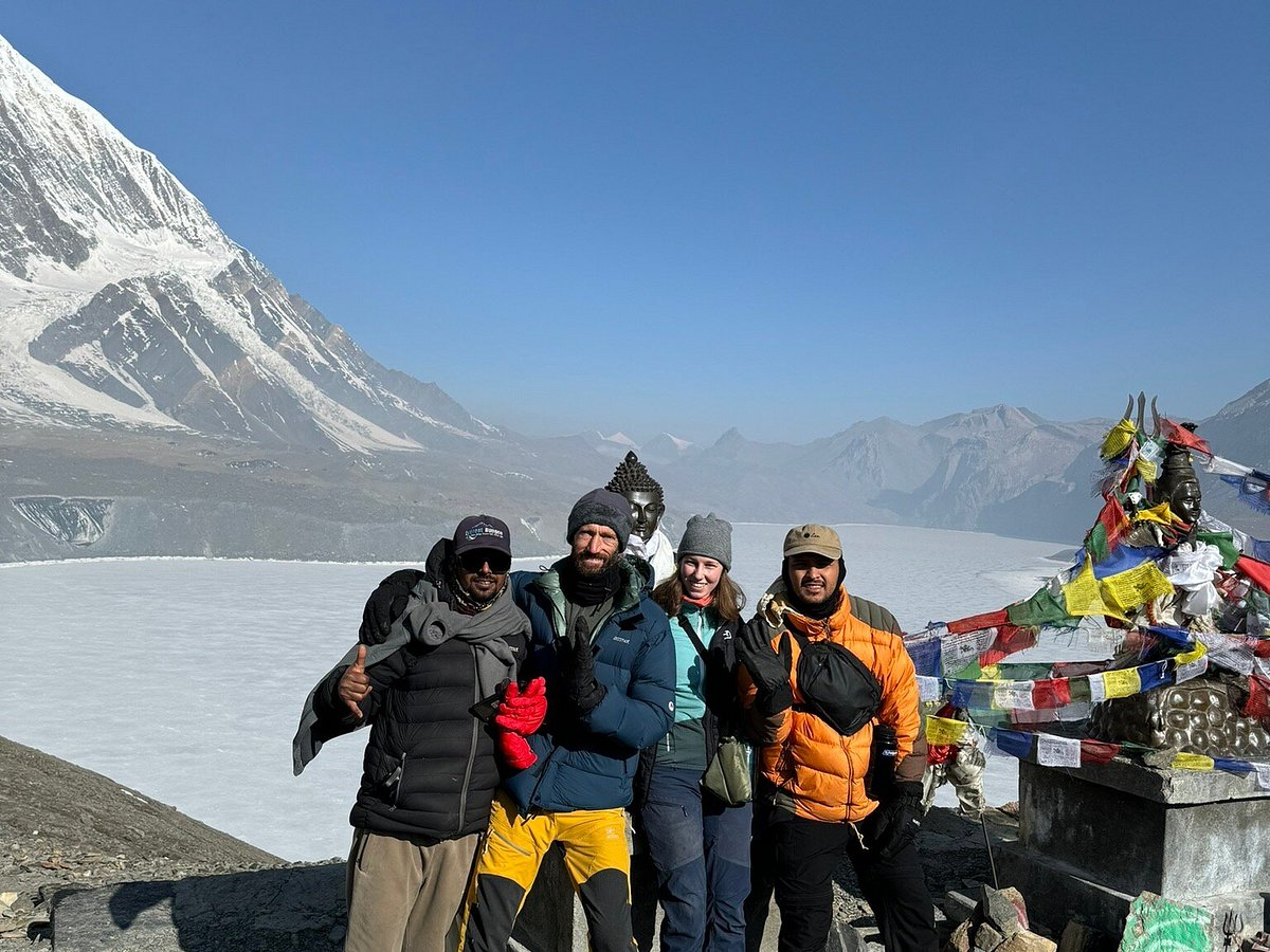 Men trekking together in the Nepalese Himalayas surrounded by snow-capped peaks and traditional prayer flags