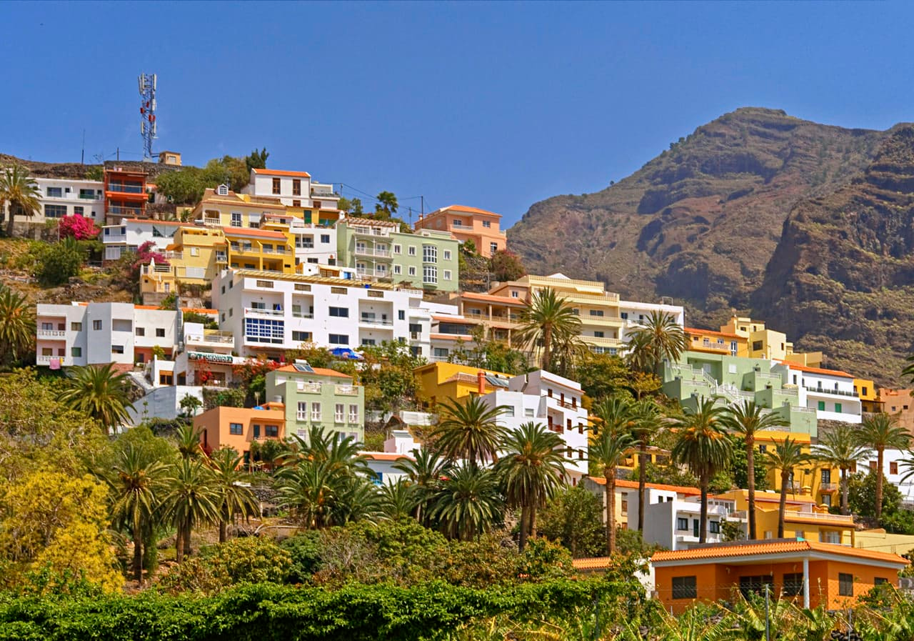 Colorful hillside village in La Gomera with traditional houses set against a mountainous backdrop