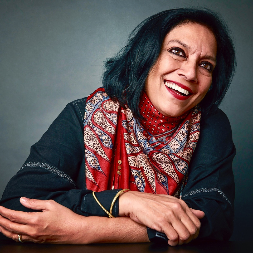 Portrait of Mira Nair with a warm smile and patterned scarf