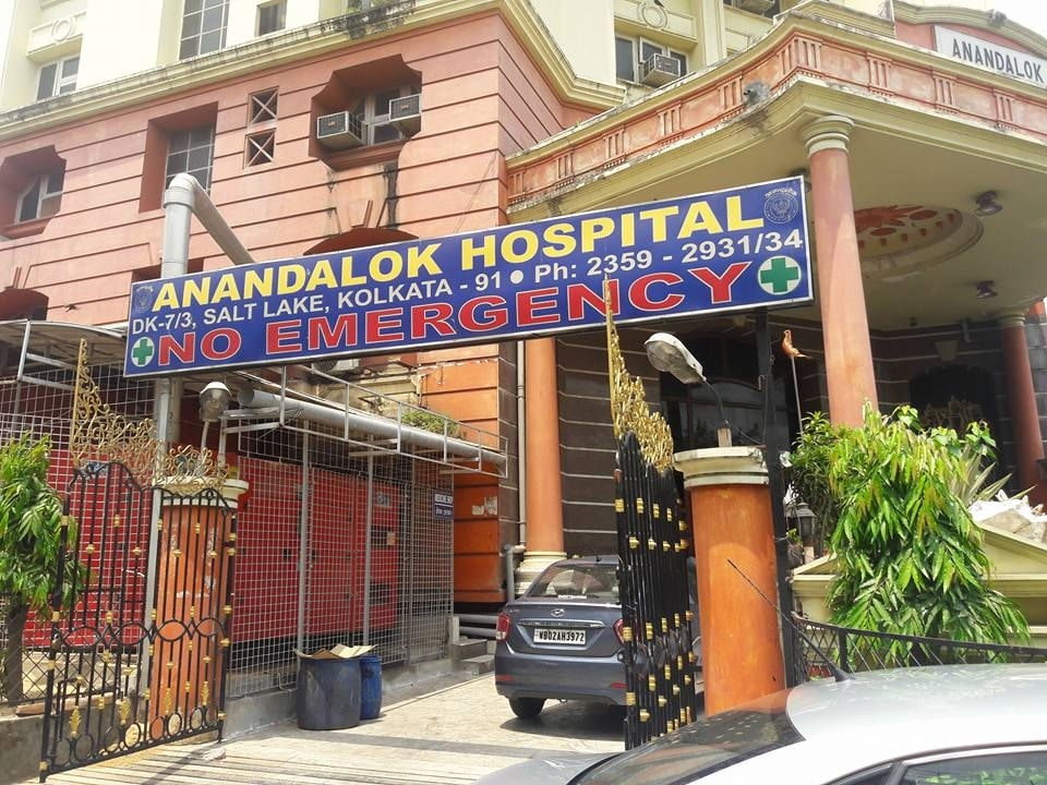 Entrance of Anandalok Hospital in Salt Lake, Kolkata, showing signboard with contact details and a notice of no emergency services