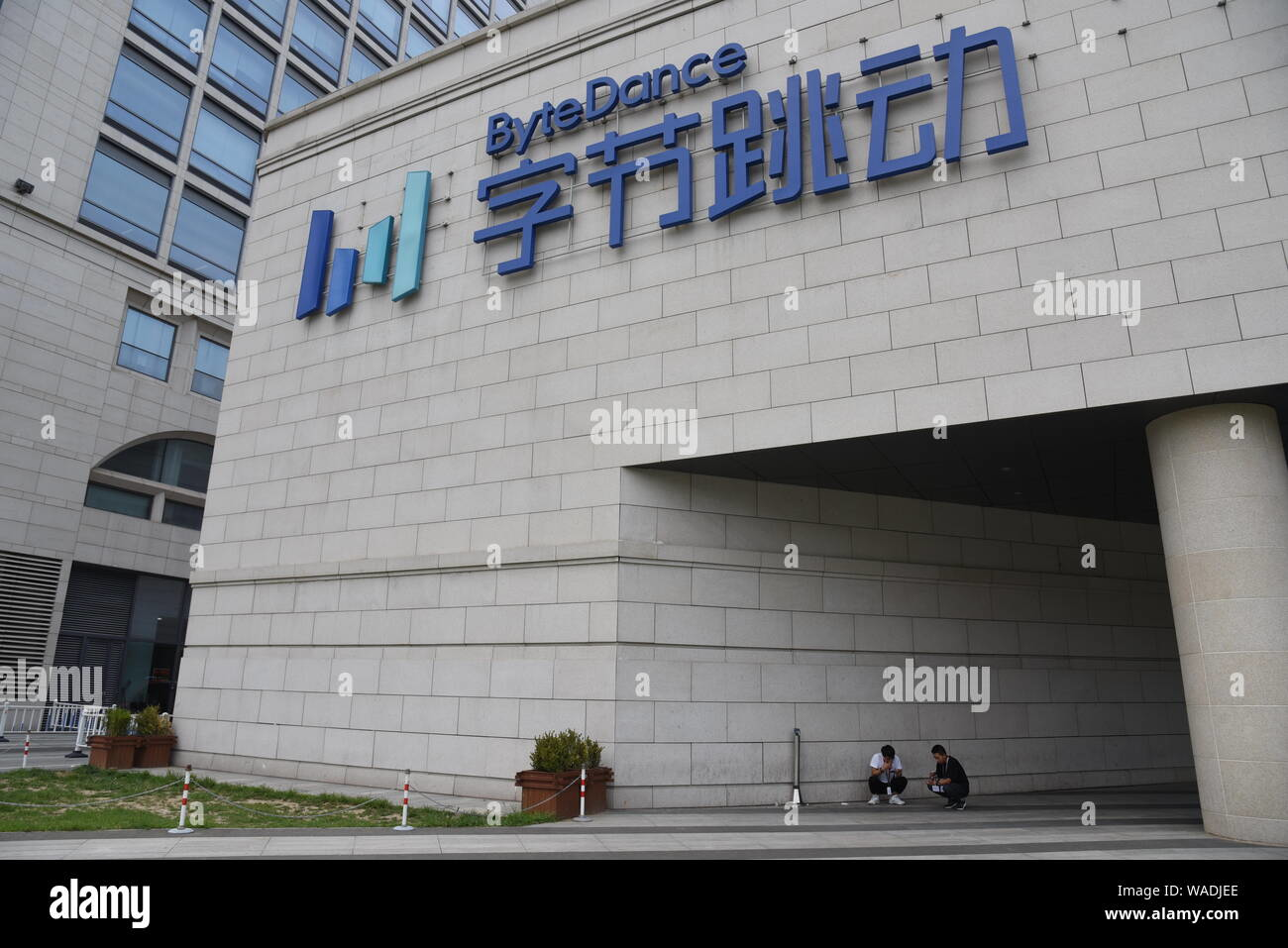Exterior of ByteDance headquarters in Beijing showing the company logo and entrance area with people