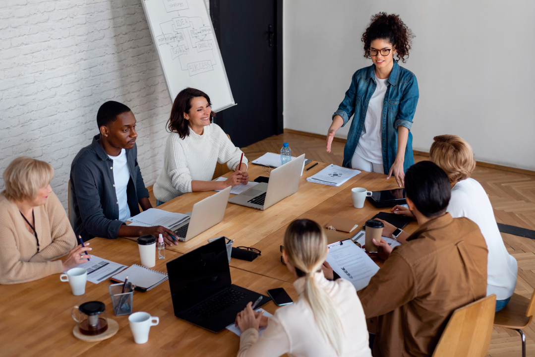 Entrepreneurs collaborating in a business meeting around a conference table with laptops and documents
