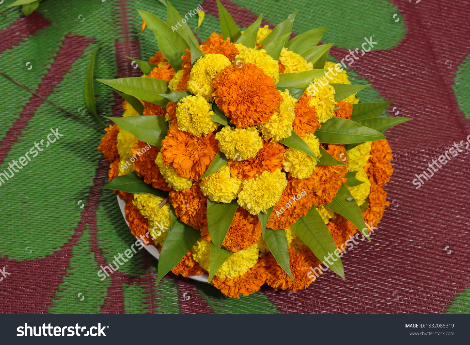 Traditional Bathukamma floral arrangement made with bright marigold flowers and green leaves in a conical gopuram shape