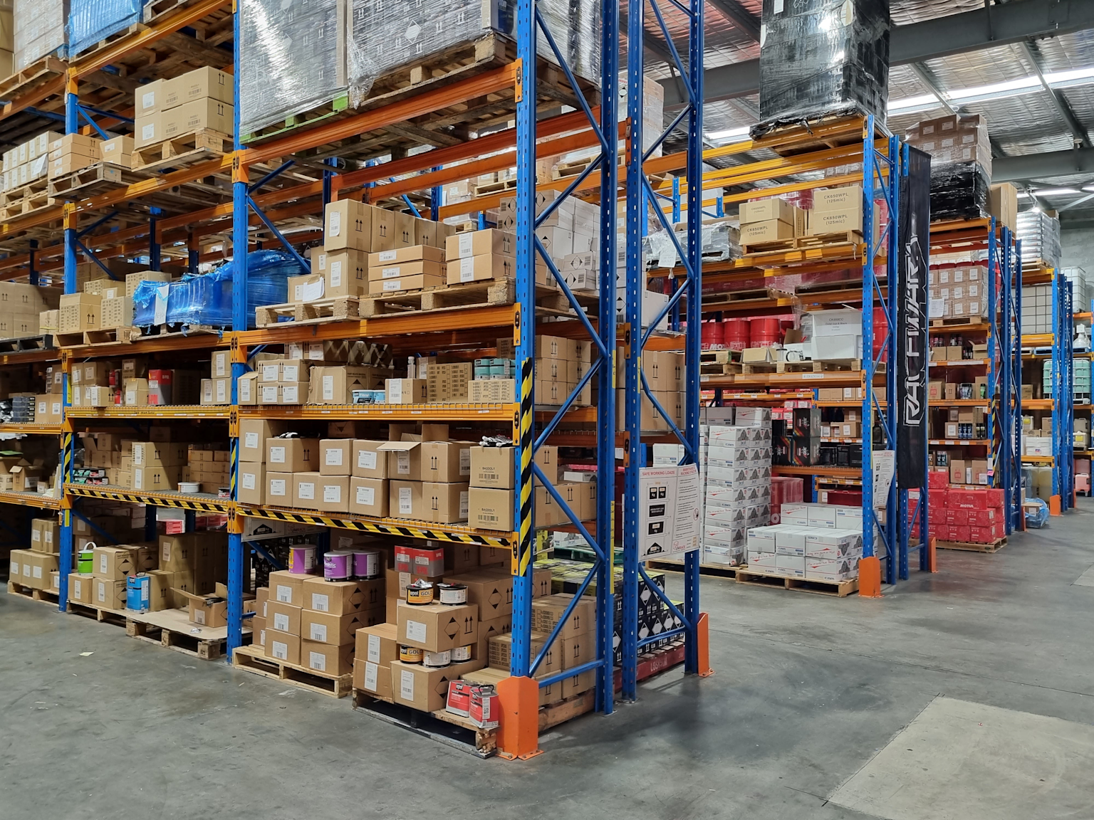 Warehouse storage racks filled with wholesale cleaning supplies packaged in bulk boxes ready for distribution