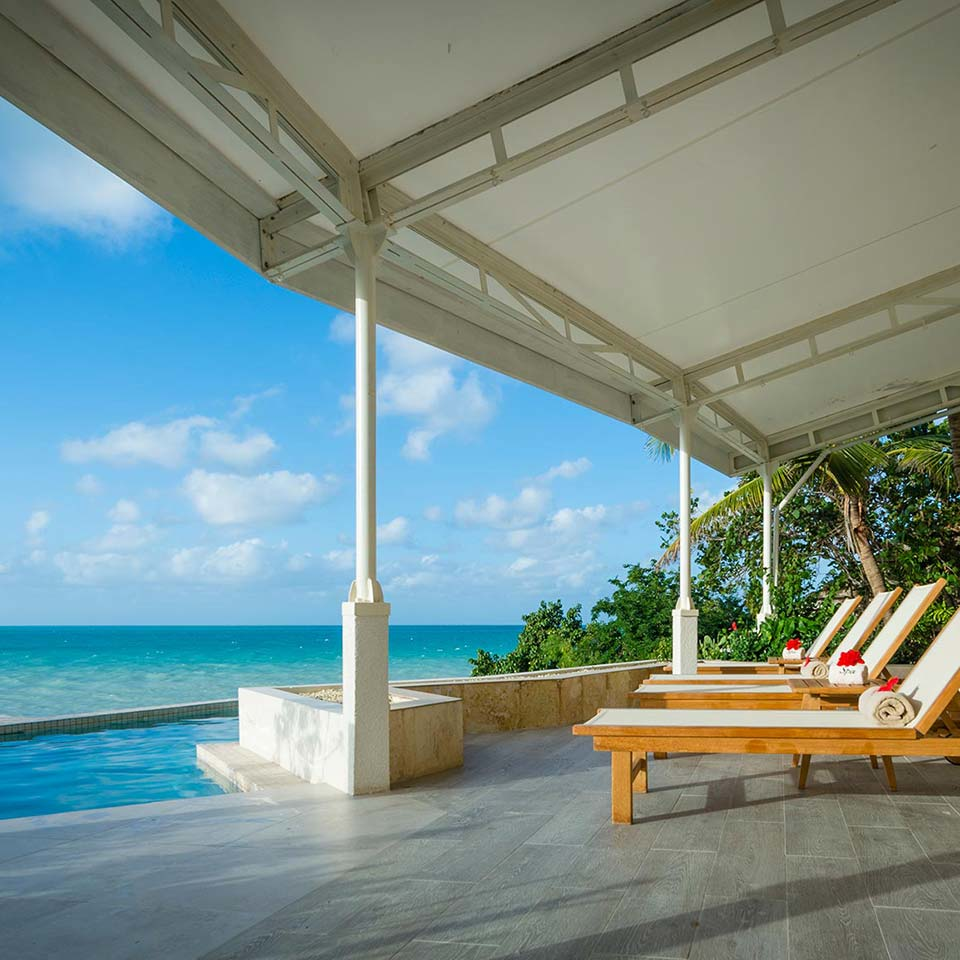 Oceanfront poolside lounge area at Blue Waters Resort & Spa, Antigua & Barbuda, ideal for luxurious relaxation and spa retreats