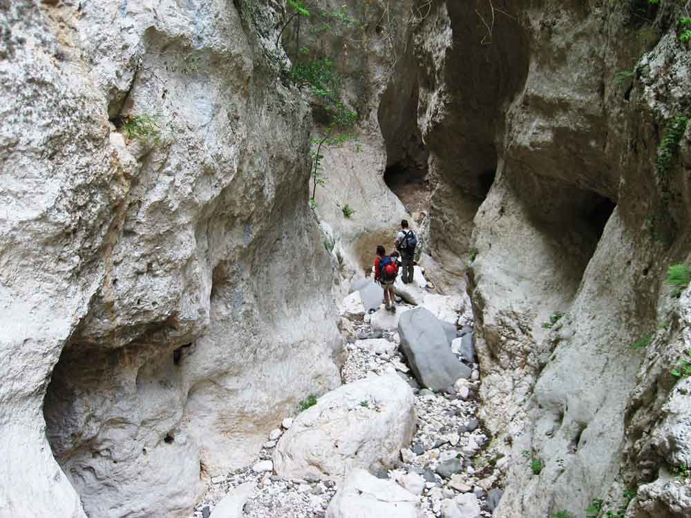 Adventurous hikers exploring the rugged Codula Fuili canyon in Sardinia on a guided canyoning tour