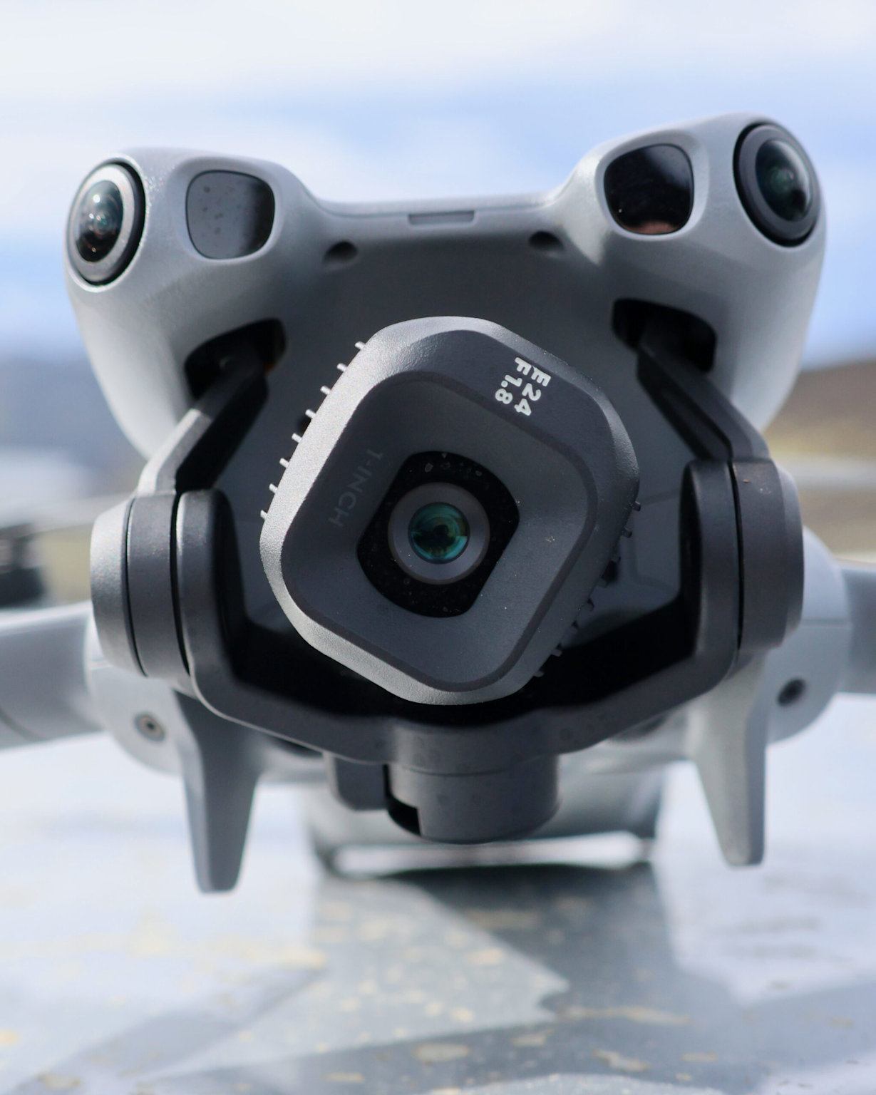 Close-up of the DJI Mini 5 Pro drone camera and its gimbal system, showing a 1-inch sensor with f/1.8 aperture suitable for vertical shooting