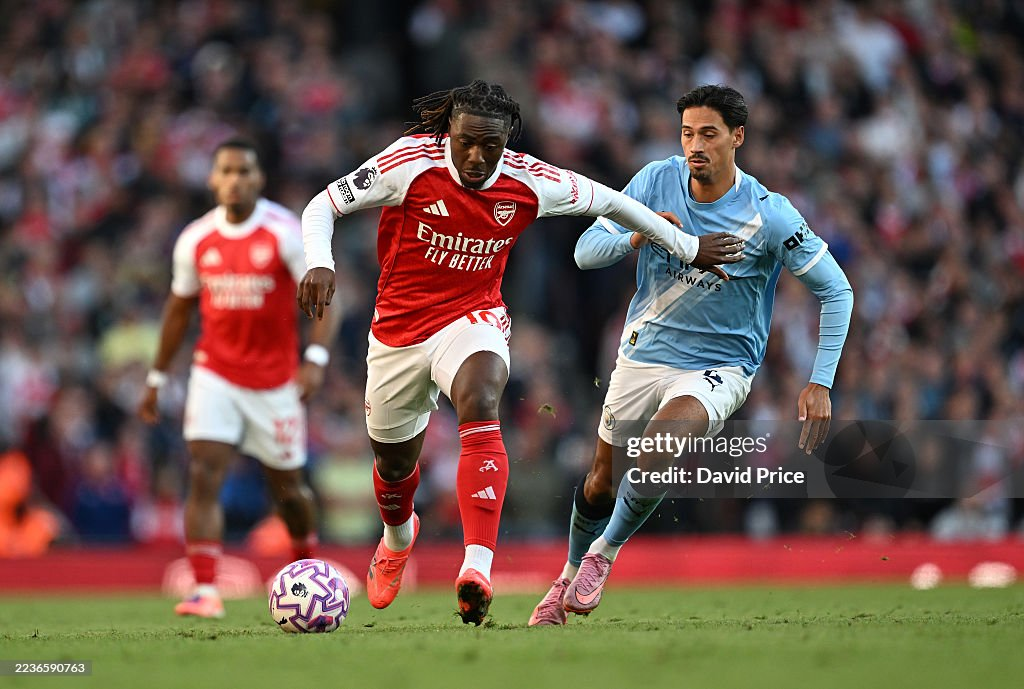 Eberechi Eze of Arsenal runs with the ball under pressure from an opponent in a competitive match