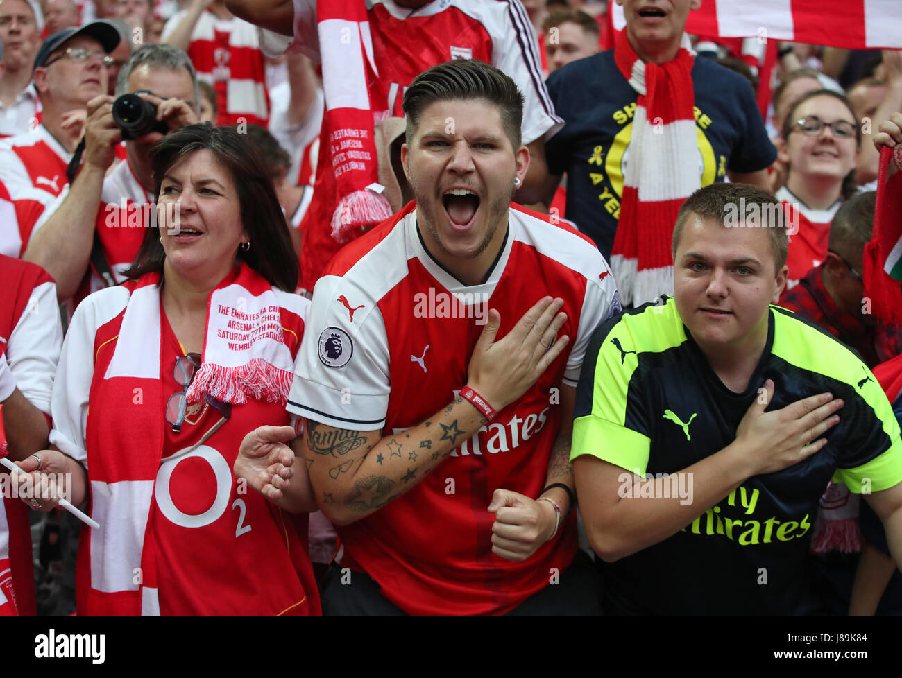Arsenal fans celebrate passionately in team colors during a match victory or significant moment