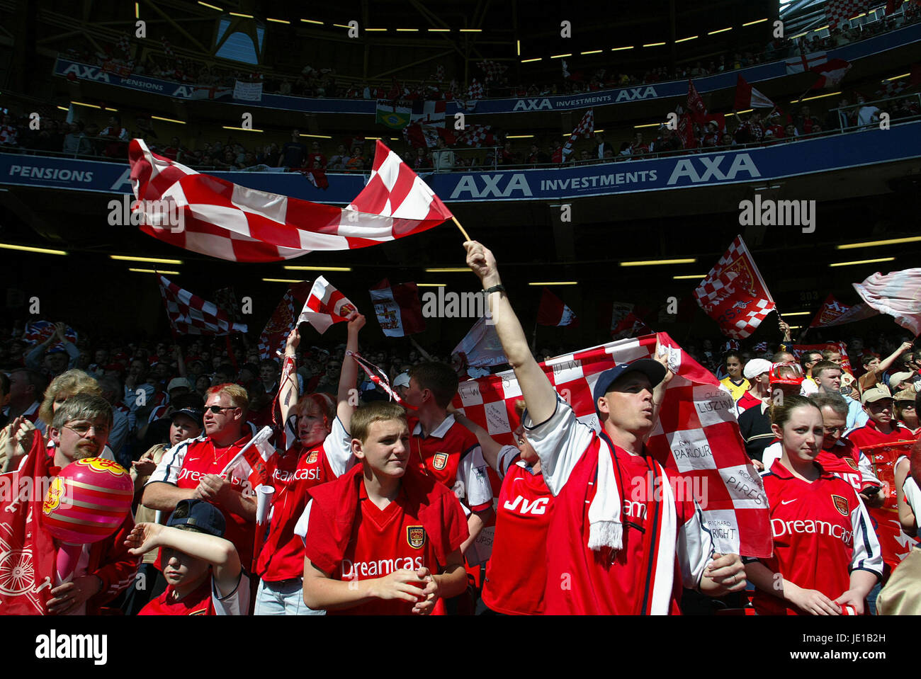 Arsenal fans celebrate with flags and jerseys in a packed stadium, capturing the lively support during a match