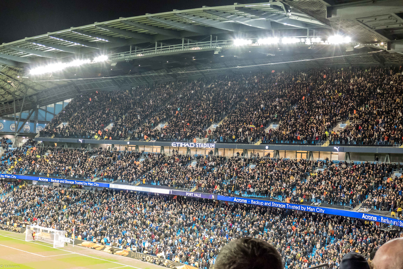A packed Etihad Stadium with a large crowd during a football match involving Port Vale