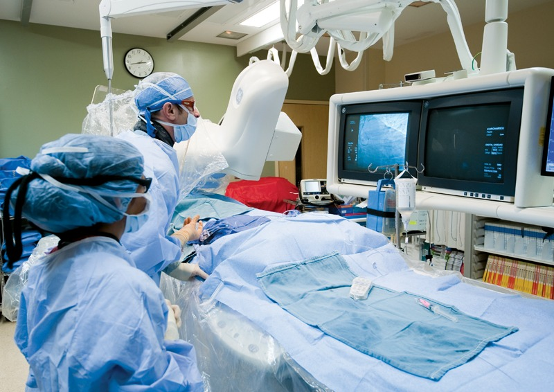 Cardiologist performing angioplasty with real-time heart imaging in a sterile surgical environment