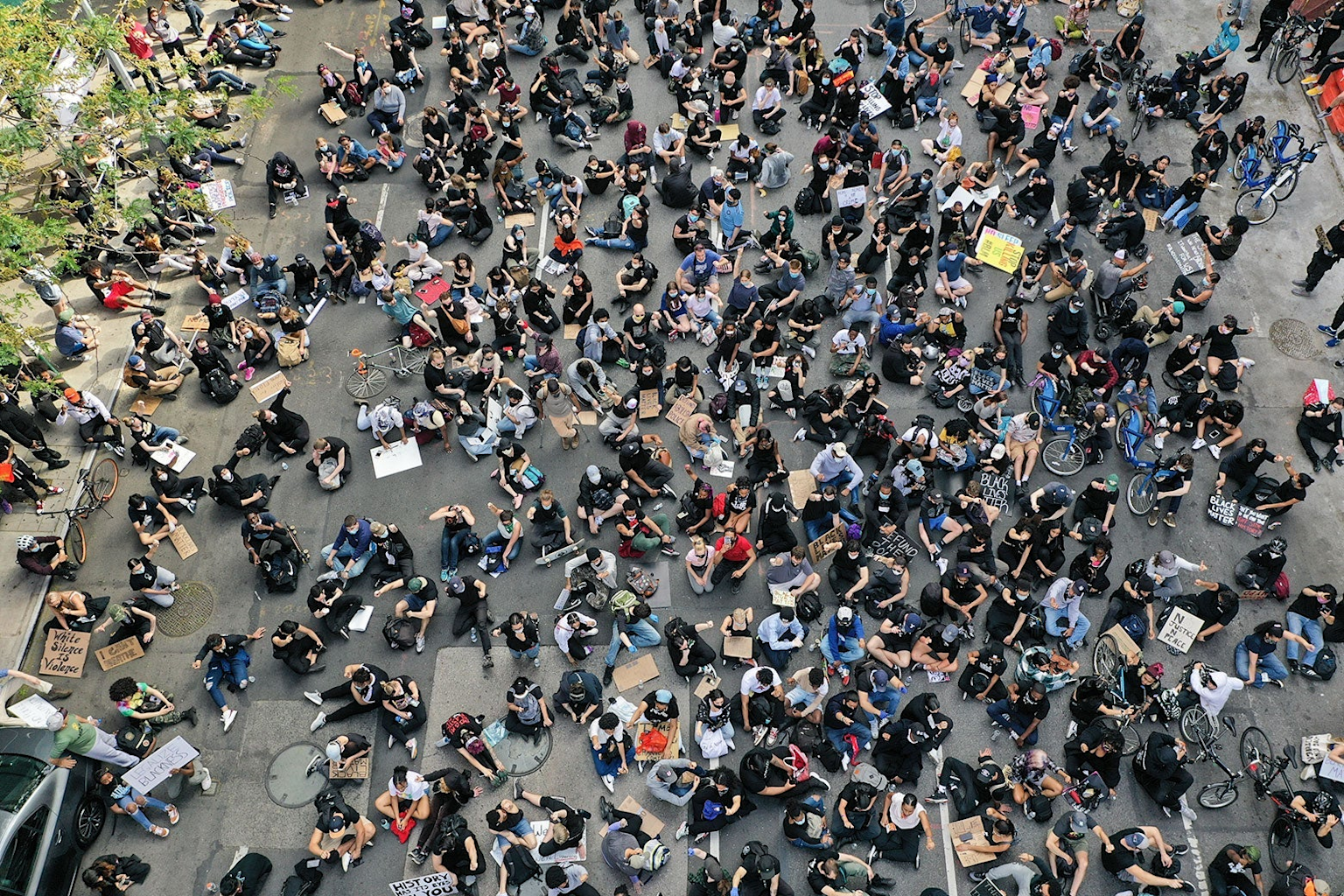 A large crowd of seated protesters viewed from above, illustrating the scale of public gatherings relevant to surveillance and crowd monitoring technologies.