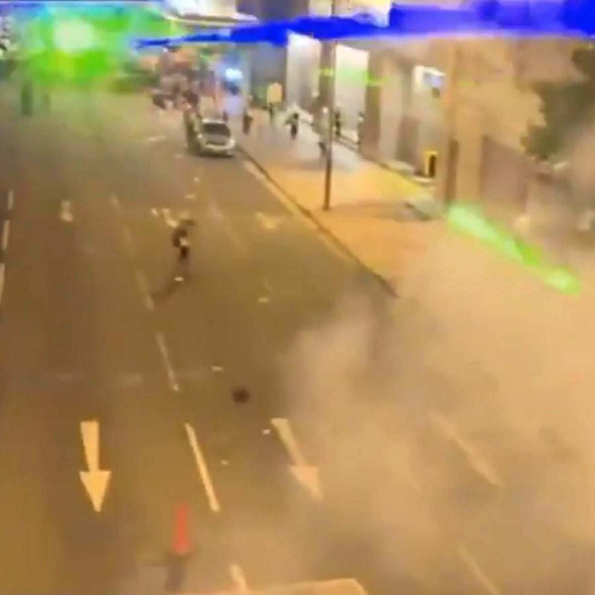 Hong Kong protesters using laser pointers at night to disrupt surveillance cameras during demonstrations.