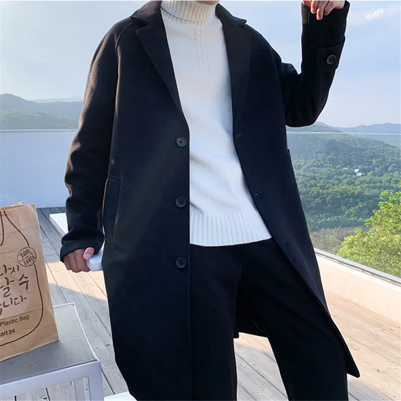 Men's oversized black wool winter coat styled with a white turtleneck sweater for a fashionable and warm winter look in 2025.