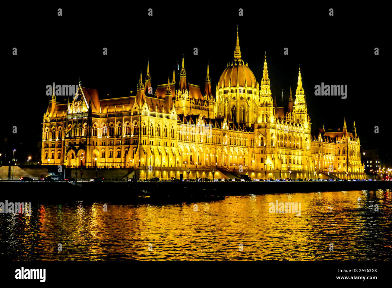 Parlamento húngaro iluminado por la noche reflejándose en el río Danubio en Budapest
