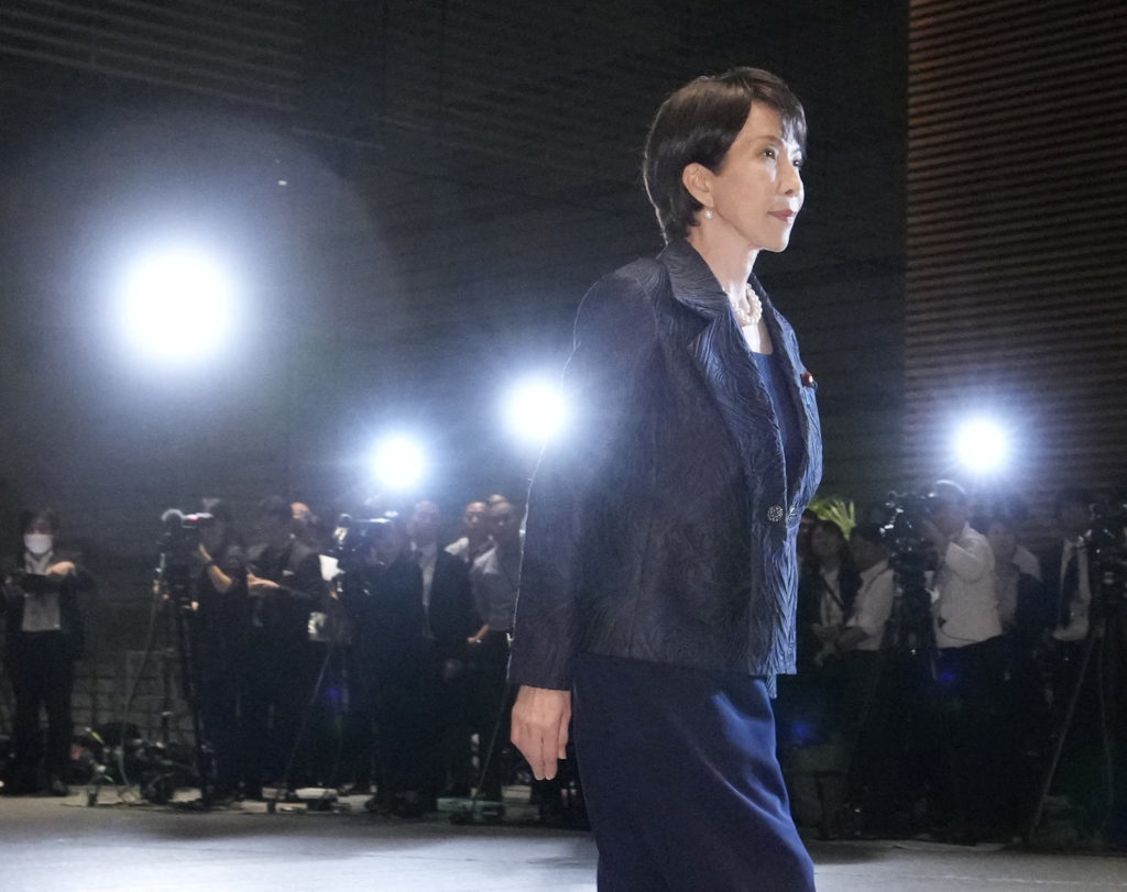 Sanae Takaichi at a formal event surrounded by media photographers during her election as Japan's ultraconservative Prime Minister