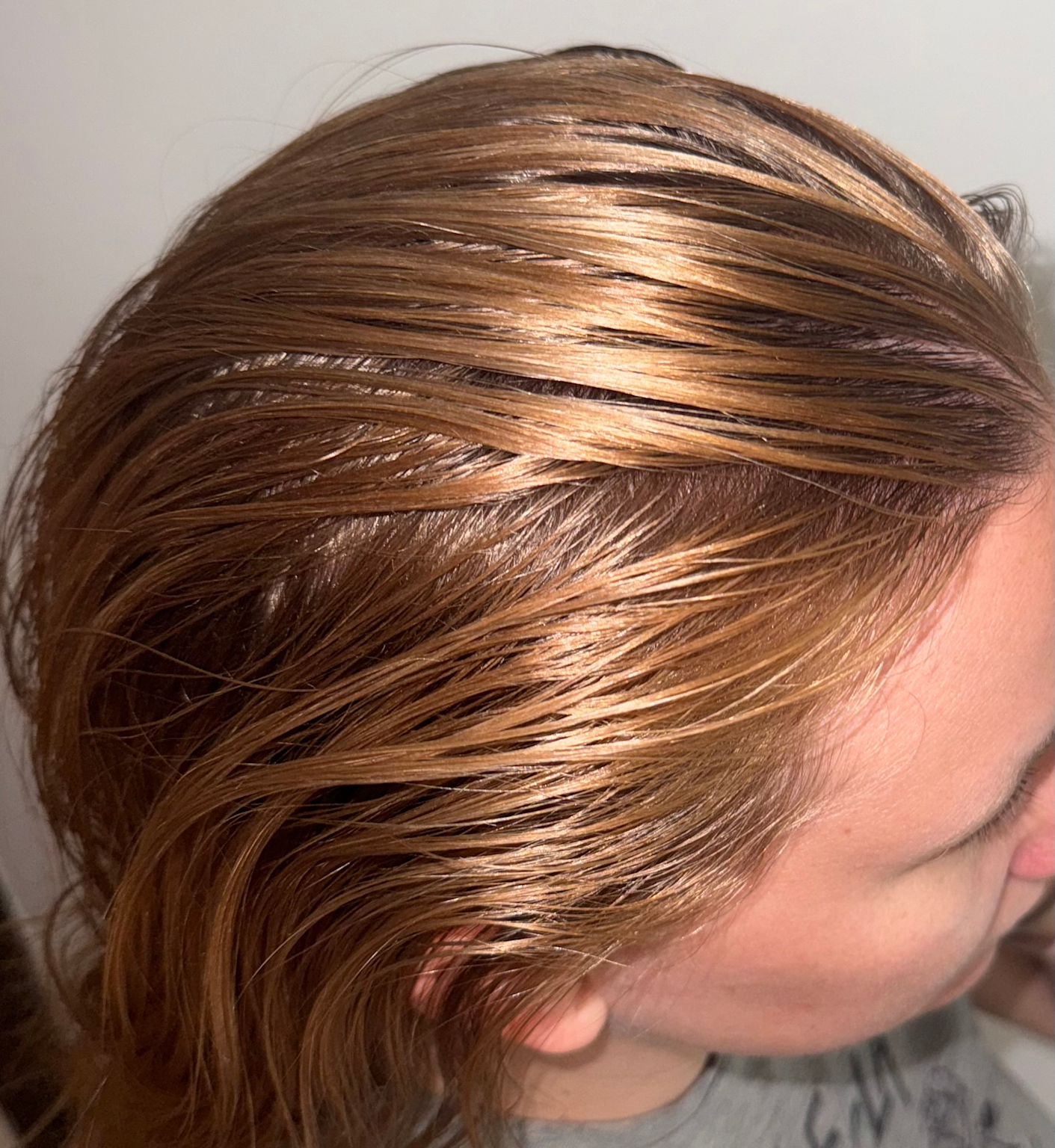 Close-up view of greasy brown hair showing shiny and oily texture