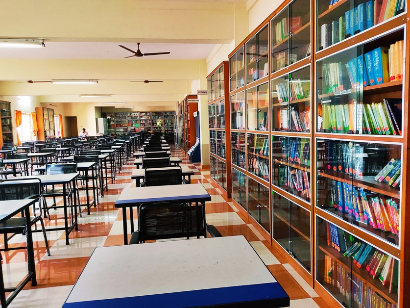 Interior of Karnataka Ayurveda Medical College library with study desks and bookshelves dedicated to Ayurveda