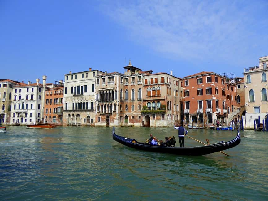 Góndola tradicional navegando por los canales de Venecia con edificios históricos venecianos de fondo