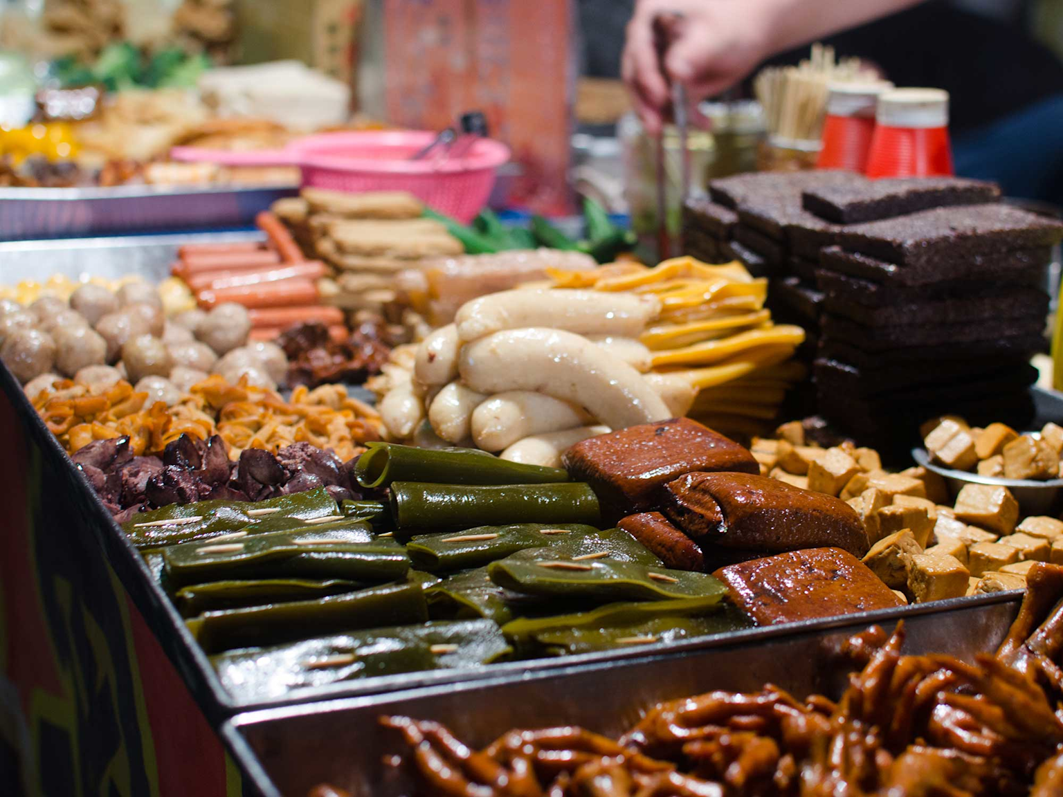 A colorful spread of traditional Taiwanese street food at a Taipei night market, showcasing the variety and cultural richness of local snacks