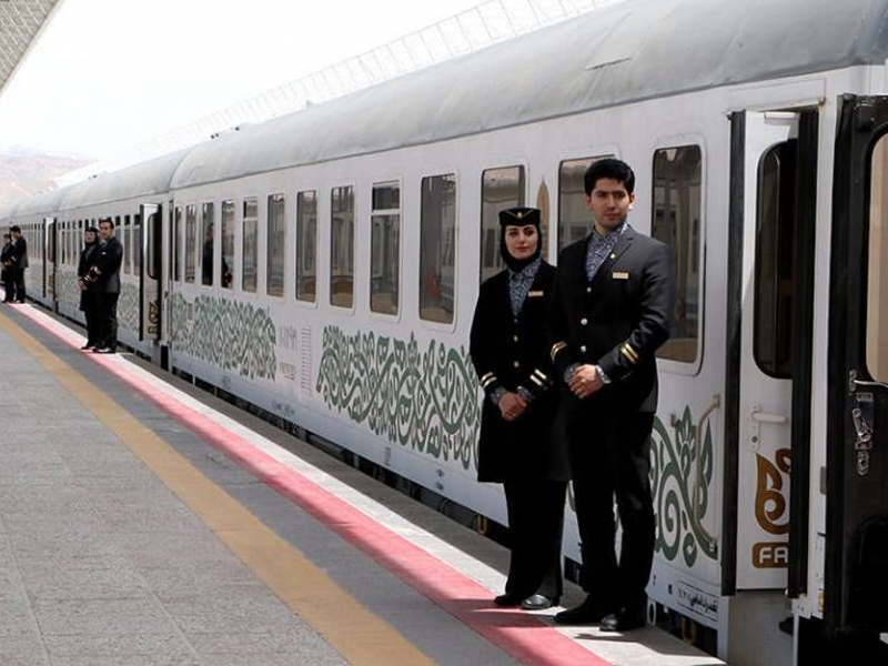 Modern train and uniformed staff indicative of professional rail service on Tehran-Mashhad route in Iran