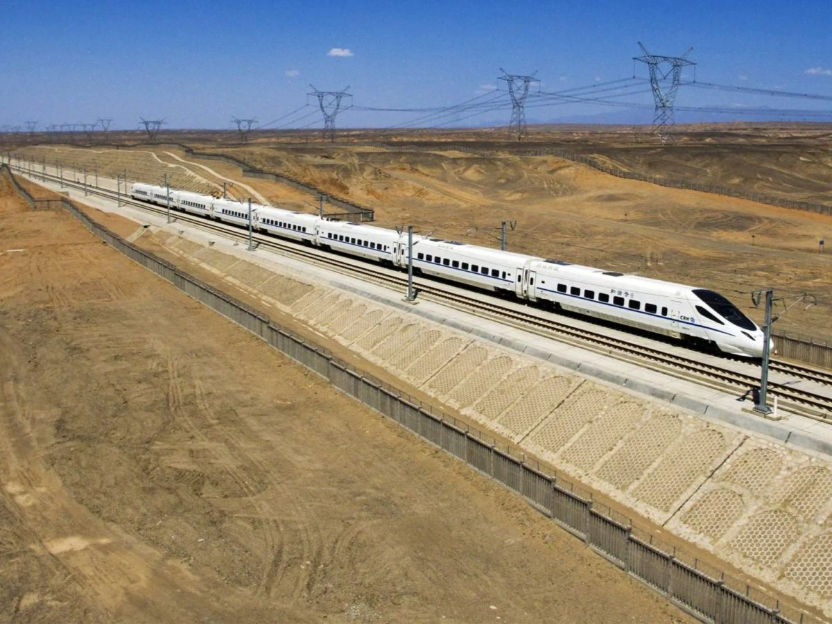 A modern high-speed train traveling through a desert area, illustrating Iran's railway infrastructure development