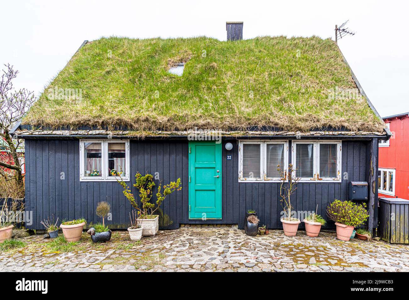 Traditional Faroese house with a grass roof and turquoise door in Tórshavn, Faroe Islands, showcasing unique local architecture